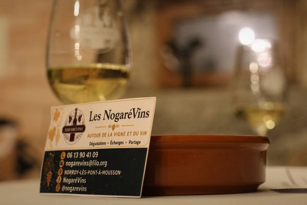 Un verre de vin blanc à la lueur des bougies, une carte de visite posée au pied